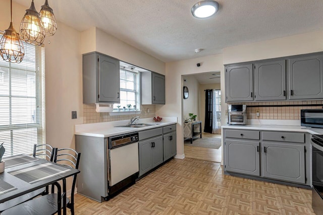 kitchen with light parquet flooring, backsplash, hanging light fixtures, and sink