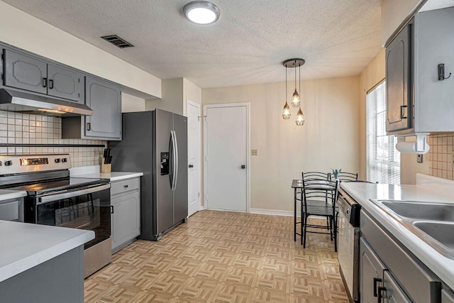 kitchen with pendant lighting, gray cabinets, stainless steel appliances, and backsplash