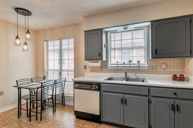 kitchen featuring light parquet flooring, backsplash, white dishwasher, gray cabinets, and sink