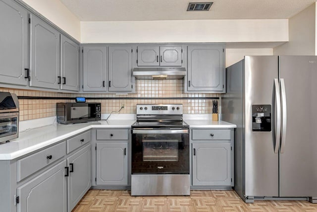 kitchen featuring tasteful backsplash, gray cabinetry, and stainless steel appliances