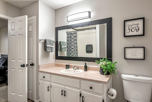 bathroom featuring vanity, toilet, and a textured ceiling