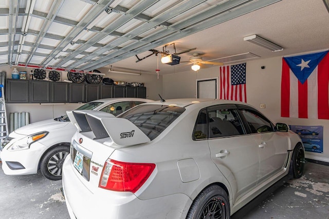 garage with a garage door opener and ceiling fan