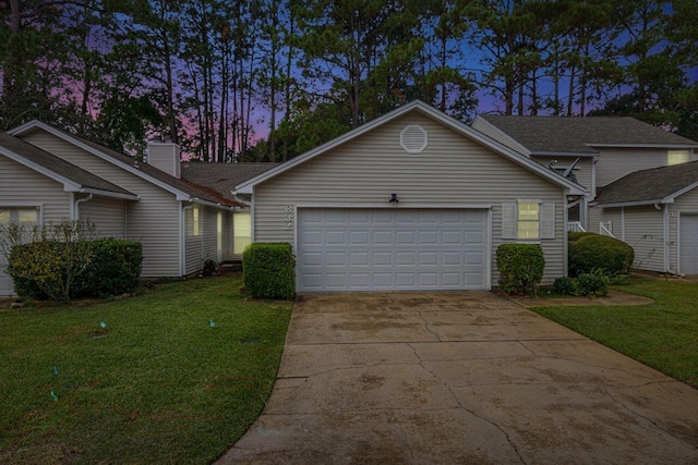 single story home with a garage and a yard