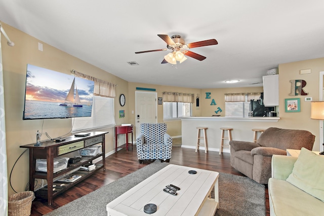 living room featuring ceiling fan and dark hardwood / wood-style flooring