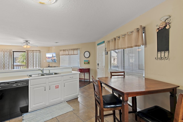 kitchen with white cabinets, black dishwasher, a textured ceiling, light tile patterned flooring, and sink