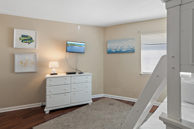 bedroom with a textured ceiling and dark hardwood / wood-style floors