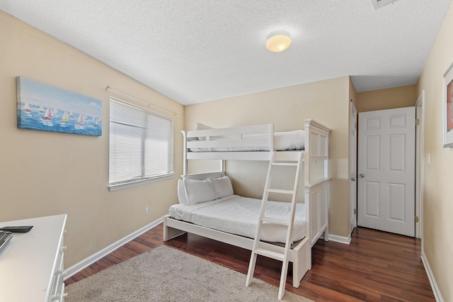 bedroom with dark wood-type flooring and a textured ceiling