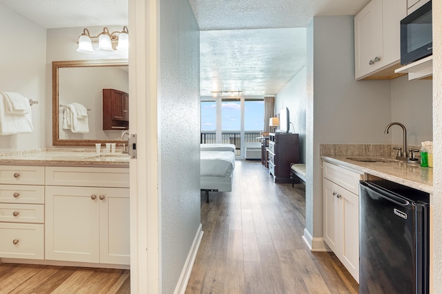 bathroom with vanity, hardwood / wood-style flooring, and a textured ceiling