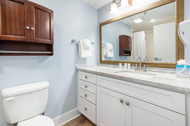 bathroom featuring toilet, hardwood / wood-style floors, and vanity