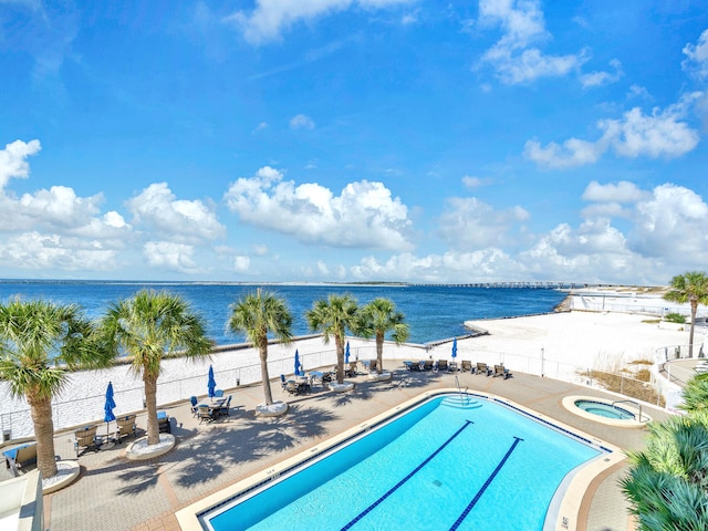 view of pool featuring a patio area, a water view, and a community hot tub