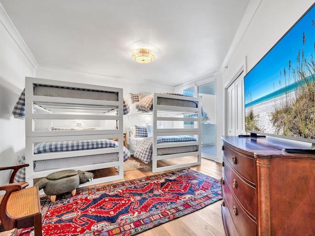 bedroom with light hardwood / wood-style flooring and crown molding