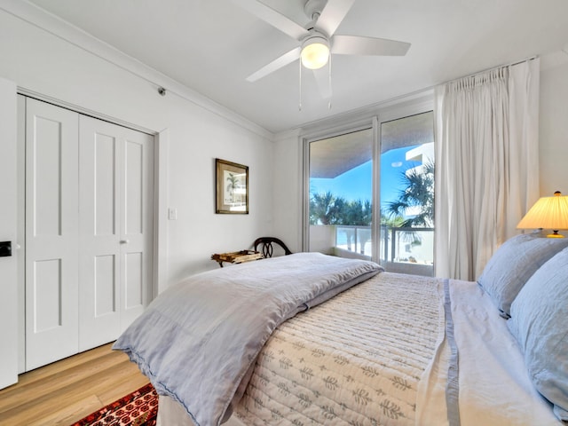 bedroom featuring wood-type flooring, access to exterior, ceiling fan, crown molding, and a closet