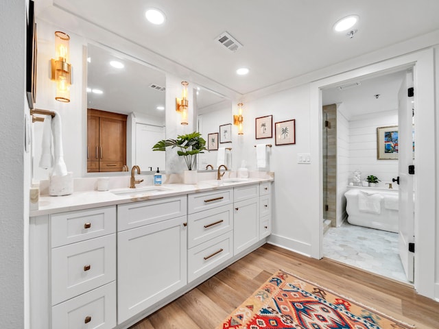 bathroom with hardwood / wood-style flooring, vanity, and separate shower and tub