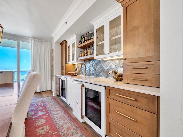 bar featuring dark wood-type flooring, tasteful backsplash, beverage cooler, and sink