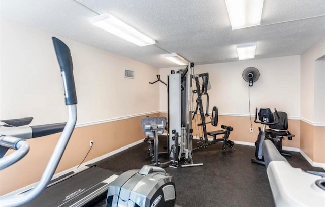 exercise room featuring a textured ceiling