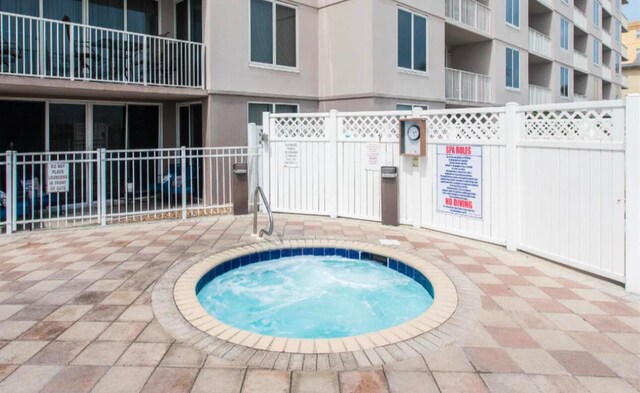 view of swimming pool featuring a community hot tub and a patio area