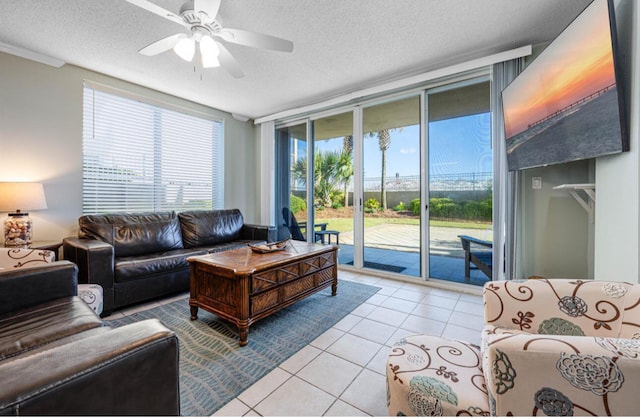 tiled living room featuring a textured ceiling, ceiling fan, and floor to ceiling windows