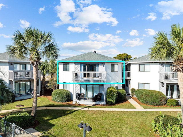 exterior space with a front lawn and a balcony