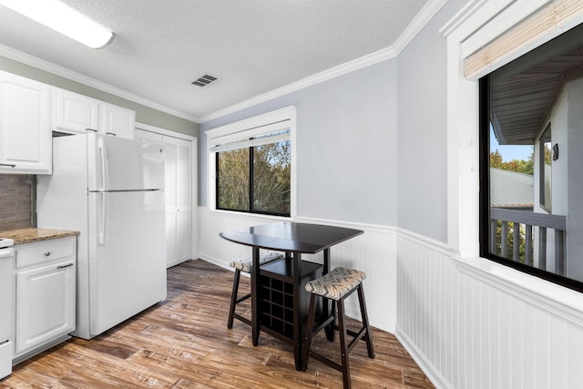 kitchen with white cabinetry, light hardwood / wood-style floors, tasteful backsplash, and white refrigerator