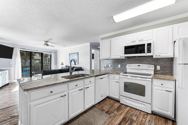 kitchen featuring kitchen peninsula, sink, white appliances, and white cabinets