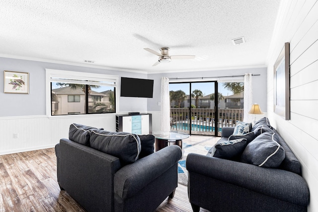 living room featuring hardwood / wood-style floors, a wealth of natural light, ceiling fan, and a textured ceiling