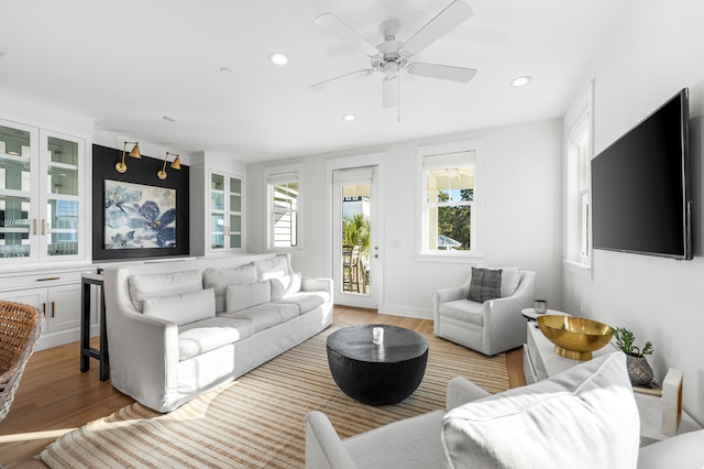 living room with hardwood / wood-style floors, ceiling fan, and plenty of natural light