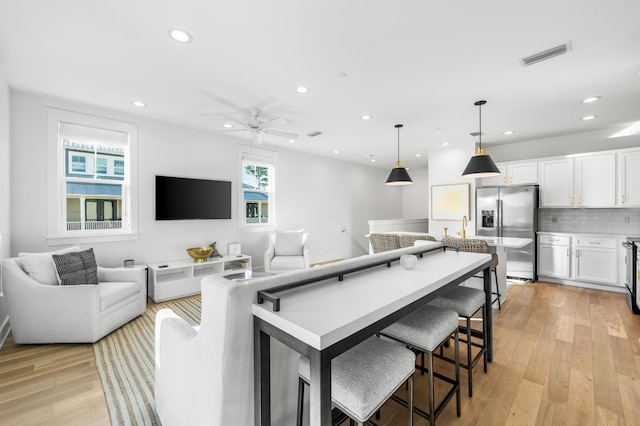 living room featuring ceiling fan and light hardwood / wood-style flooring