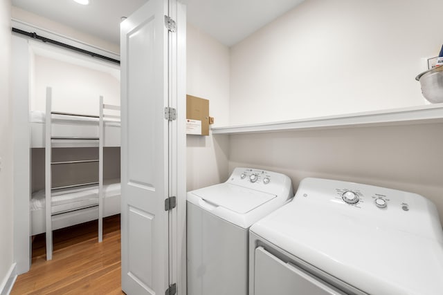 clothes washing area featuring washing machine and dryer and light hardwood / wood-style floors