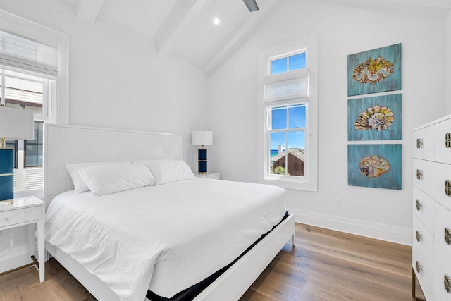 bedroom featuring vaulted ceiling with beams, multiple windows, wood-type flooring, and ceiling fan