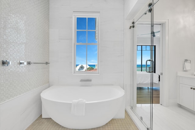 bathroom with vanity, tile walls, tile patterned floors, and plus walk in shower