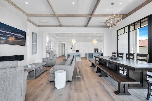 dining area with beam ceiling, wooden ceiling, a chandelier, and light wood-type flooring