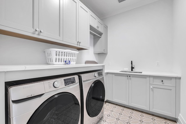 washroom featuring sink, washing machine and dryer, and cabinets