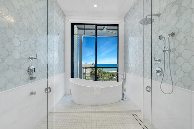 bathroom featuring tile walls, shower with separate bathtub, and tile patterned flooring