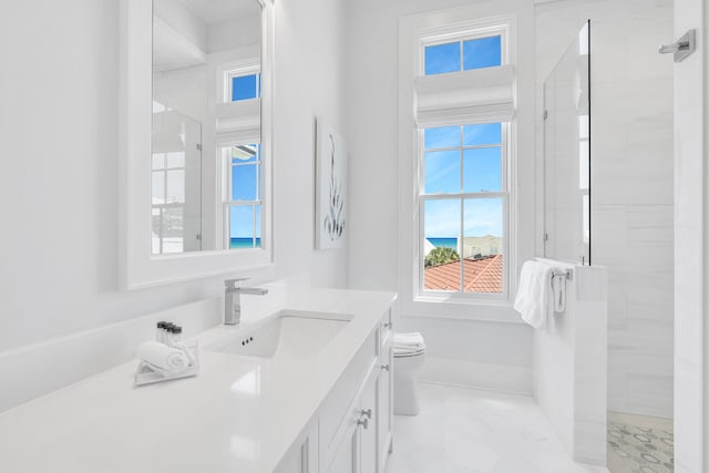 bathroom featuring vanity, toilet, and a tile shower