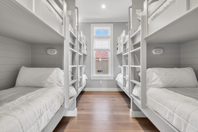 bedroom with dark wood-type flooring and wooden walls