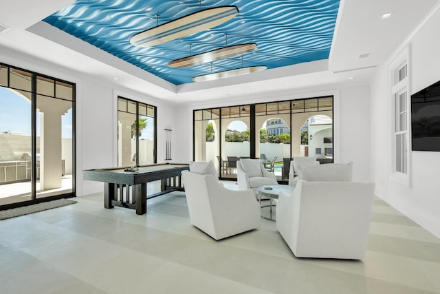 living room with a tray ceiling and pool table