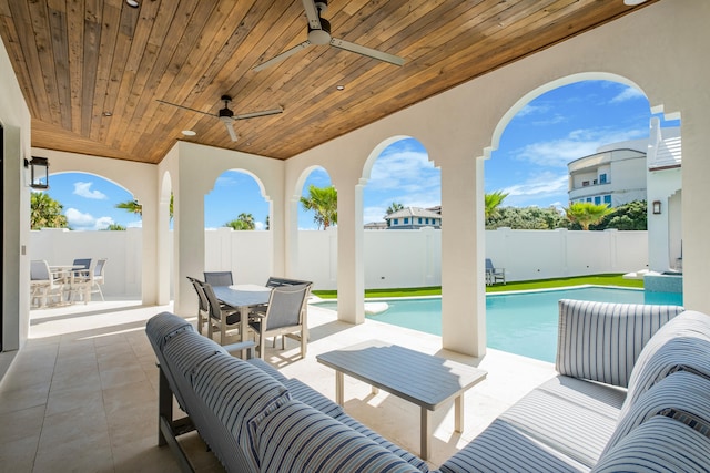 view of patio / terrace featuring ceiling fan and a fenced in pool