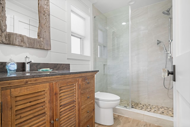 bathroom featuring walk in shower, vanity, hardwood / wood-style flooring, and toilet