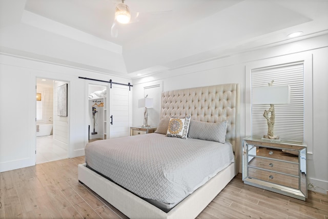4639 Destiny Way, Destin, FL 32541 - bedroom with a barn door, wood finished floors, a raised ceiling, recessed lighting, and a spacious closet