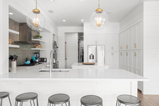 kitchen with pendant lighting, kitchen peninsula, appliances with stainless steel finishes, and a kitchen breakfast bar