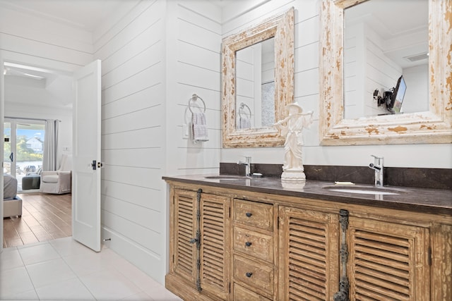 bathroom with wooden walls, vanity, wood-type flooring, and ornamental molding