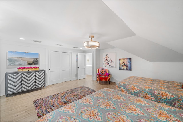 bedroom with light hardwood / wood-style floors and a closet