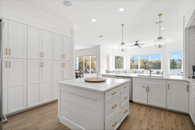 kitchen featuring light hardwood / wood-style floors, hanging light fixtures, sink, and a healthy amount of sunlight