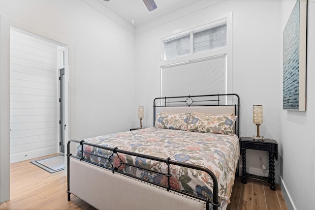 bedroom with crown molding, hardwood / wood-style flooring, and ceiling fan