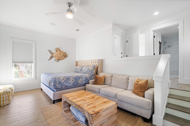 bedroom with ornamental molding, ensuite bath, wood-type flooring, and ceiling fan