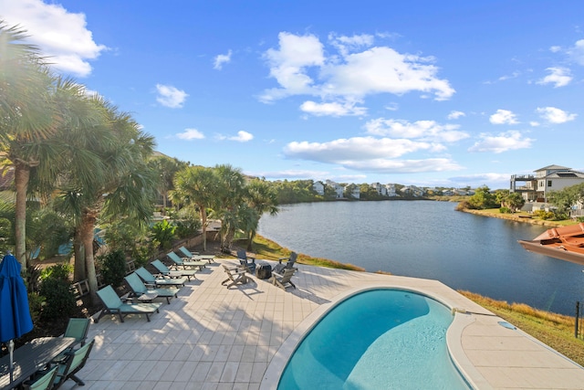 view of swimming pool with a water view and a patio area