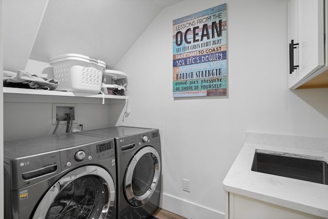 laundry room with hardwood / wood-style floors, cabinets, sink, and washing machine and clothes dryer