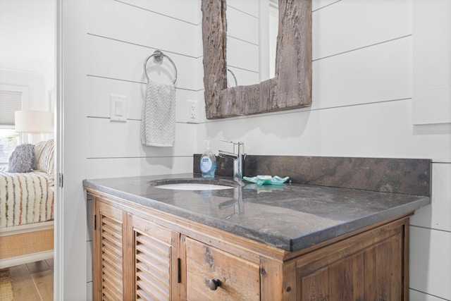 4639 Destiny Way, Destin, FL 32541 - kitchen featuring a sink, wood finished floors, brown cabinetry, and dark stone counters