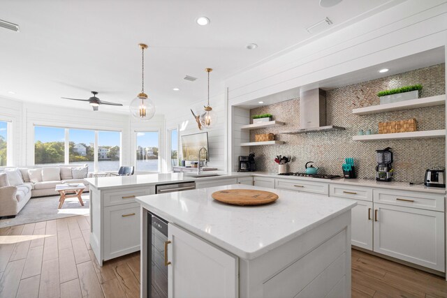 4639 Destiny Way, Destin, FL 32541 - kitchen with open shelves, a center island, wall chimney exhaust hood, a sink, and backsplash