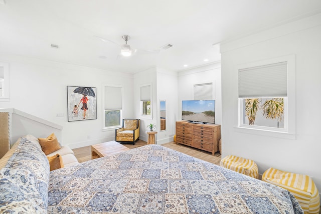 bedroom with ornamental molding, light wood-type flooring, and ceiling fan